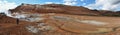 Panoramic view at Hverarond hydrothermal site in Northern Island. People follow walk passes between hot sources, fumaroles, mud